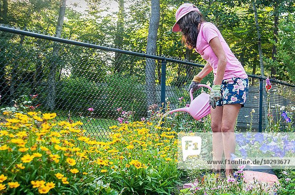 Woman watering flowers in garden