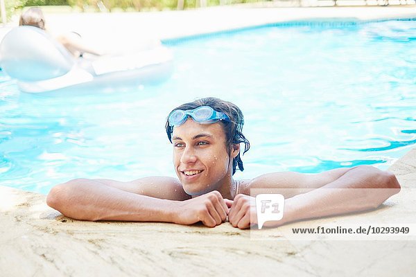 Porträt eines lächelnden jungen Mannes mit nassen Haaren im Schwimmbad