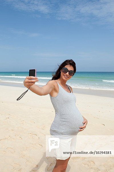 Schwangere mittlere erwachsene Frau mit Smartphone Selfie am Strand  Kap Verde  Afrika