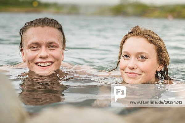 Portrait of young couple relaxing in Secret Lagoon hot spring (Gamla Laugin)  Fludir  Iceland