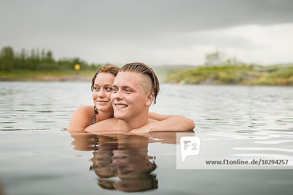 Young couple looking sideways from Secret Lagoon hot spring (Gamla Laugin)  Fludir  Iceland