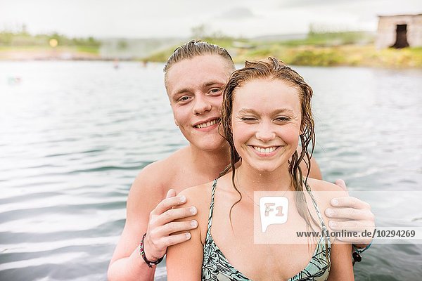 Portrait of smiling young couple standing in Secret Lagoon hot spring (Gamla Laugin)  Fludir  Iceland