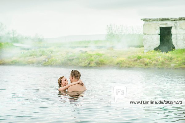 Romantic young couple relaxing in Secret Lagoon hot spring (Gamla Laugin)  Fludir  Iceland