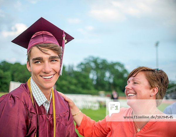Junger Mann stehend mit Mutter bei der Abschlussfeier