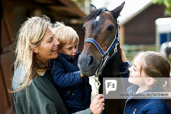 Reife Frau mit Sohn und Tochter Streichelpferd