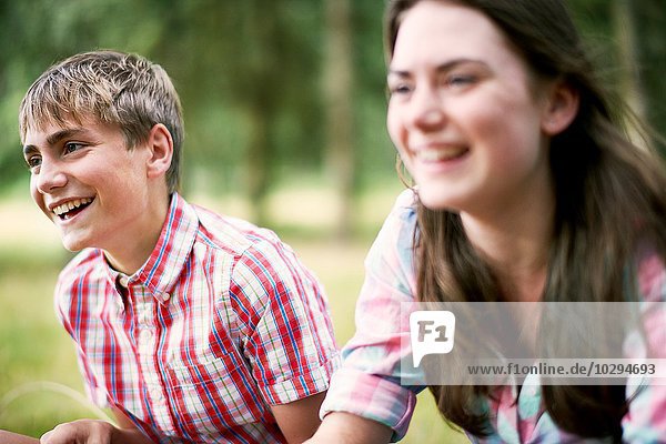 Teenager Geschwister lachend im Wald