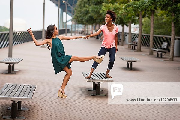 Junge Frauen tanzen und balancieren auf einem Bein