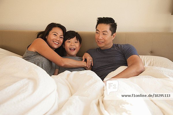 Porträt von reifen Eltern und Sohn im Bett