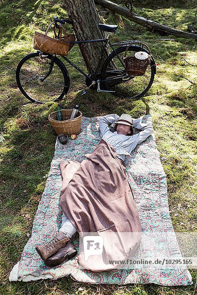 Mature female forager resting on blanket in forest