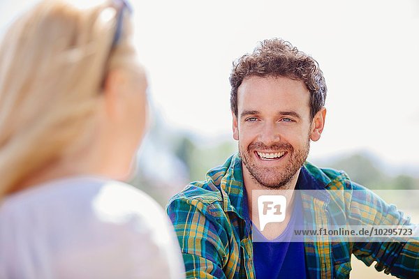 Over shoulder view of mid adult man sitting smiling at young woman