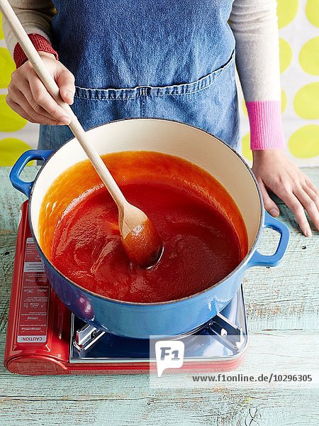 Frau bereitet Tomatenketchup zu  Schritt 3  Rühren von pürierten Tomaten