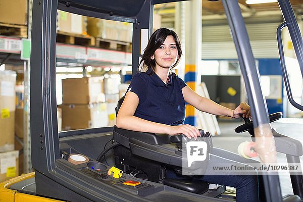 Portrait of female forklift truck driver working in distribution warehouse