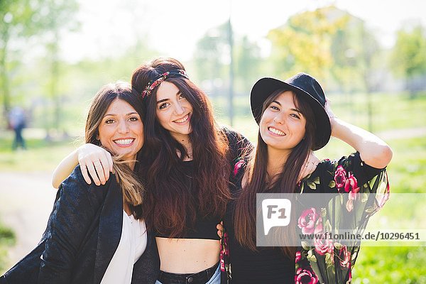 Portrait of three stylish young female friends in park
