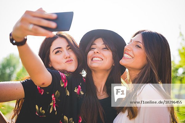 Drei junge Freundinnen nehmen Smartphone-Selfie im Park mit