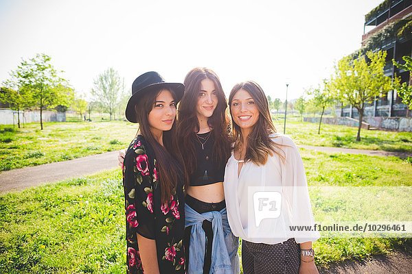Portrait of three young female friends in park