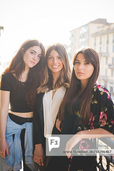 Portrait of three young female friends on city balcony