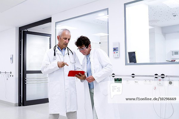 Two doctors looking at digital tablet