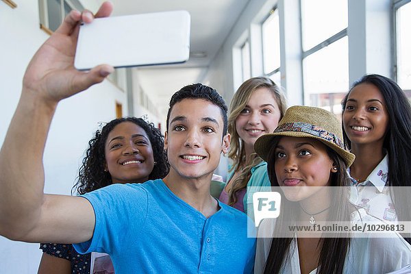 Studenten  die im Flur stehen und Selfie nehmen.