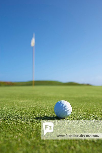 Nahaufnahme von Golfball und Golfflagge auf dem Golfplatz