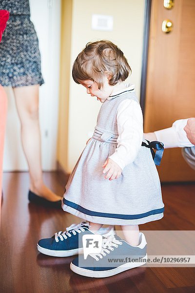 Female toddler wearing large trainer shoes