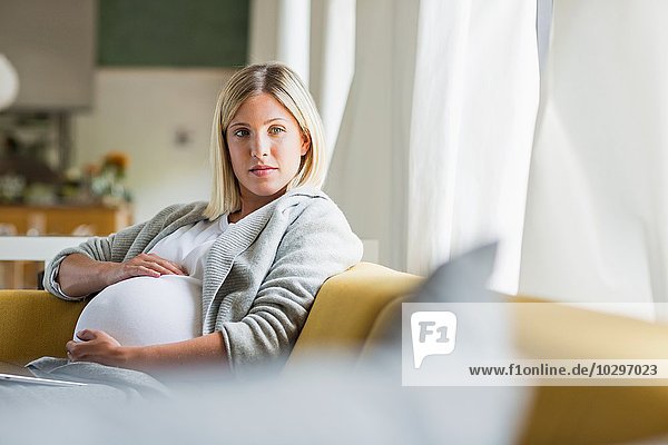 Vollzeitschwangerschaft junge Frau mit Bauch auf dem Sofa