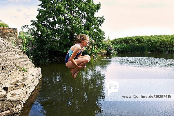 Seitenansicht des Mädchens beim Sprung in den See