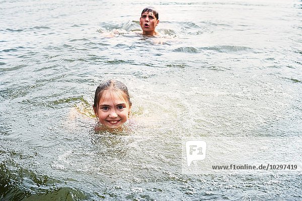 Teenager Junge und Schwester schwimmen im ländlichen See
