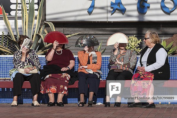 Women protecting their faces from the sun with fans  Las Palmas  Gran Canaria  Canary Islands  Spain  Europe