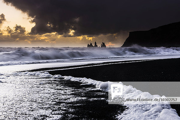 Strand  Reynisdrangar bei Sonnenuntergang mit Meeresbrandung  schwarzer Sand  bei Vik  Südisland  Island  Europa