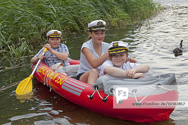 Children in a rubber dinghy  inflatable boat  Barumer lake  Barum  Lower Saxony  Germany  Europe