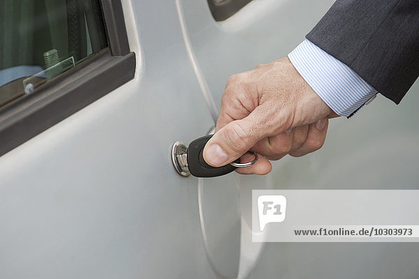 Man unlocking car door with key  cropped