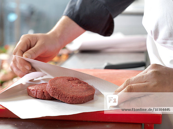 Metzger umhüllt Rinderfilets in Wachspapier  geschnitten