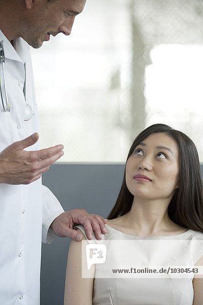 Arzt spricht mit Patient im Wartezimmer
