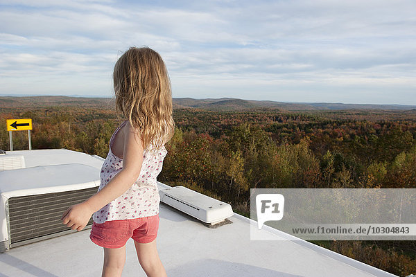 Kleines Mädchen auf dem Wohnmobil stehend  mit Blick auf die Landschaft