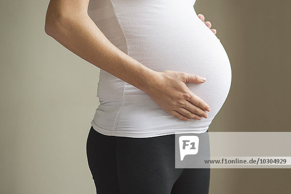 Schwangere Frau  die den Bauch berührt