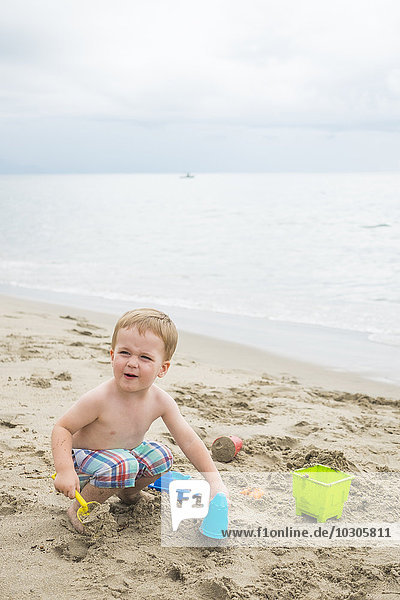 Mexiko  Kleinkind spielt am Strand am Meer
