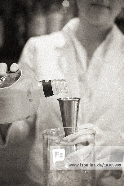 Eine Frau  die einen Cocktail mixt  ein Mixologe bei der Arbeit.