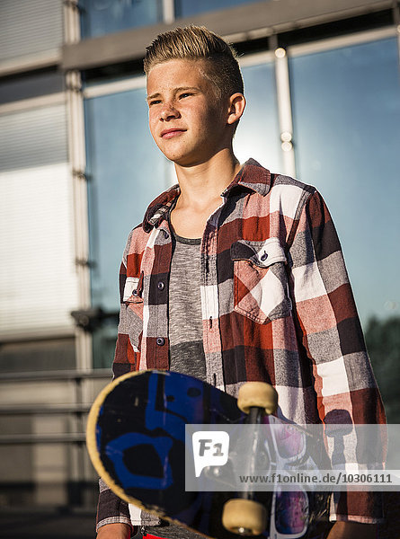 Zuversichtlicher Teenager mit Skateboard
