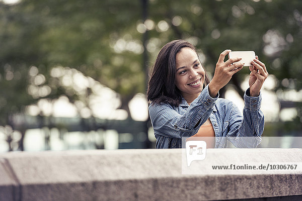 Eine Frau  die ein Foto oder einen Selfie mit einem Smartphone macht