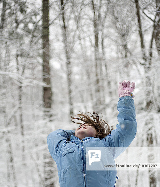 Girl throwing snow in the woods