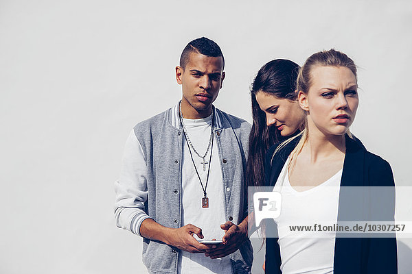 Group of three young people in front of white background