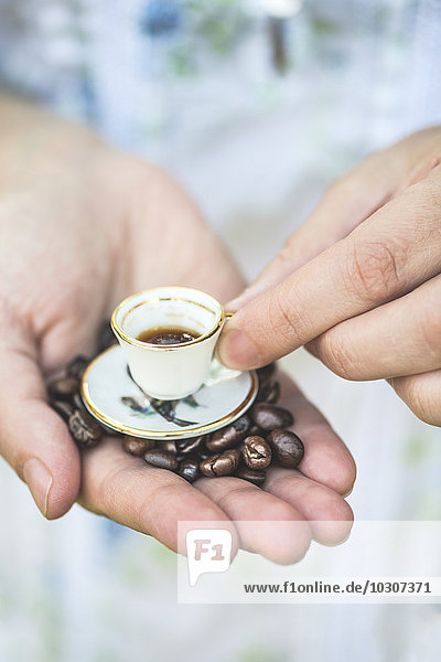 Hand halten sehr kleine Tasse Kaffee