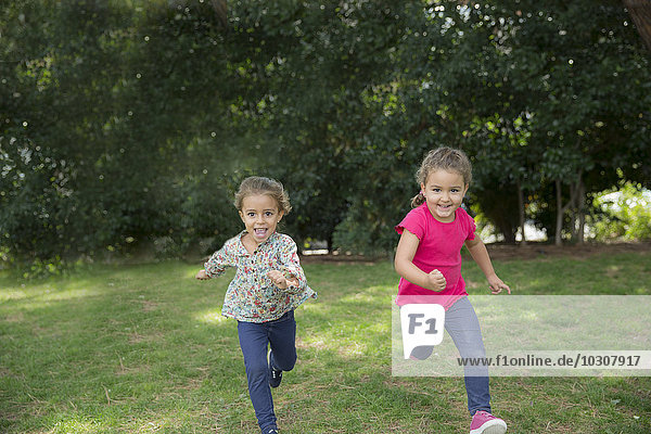 Two girls running in a park