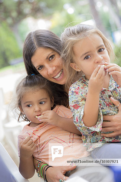 Woman with two little girls sitting on her lap