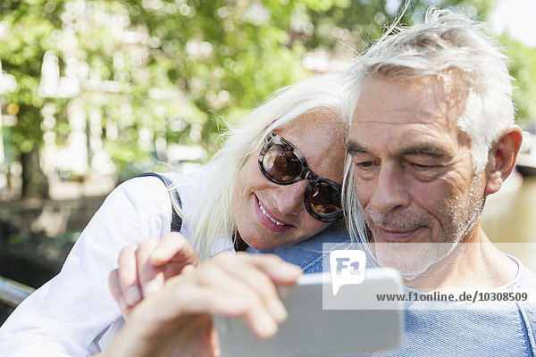 Niederlande  Amsterdam  Seniorenpaar mit einem Selfie am Stadtkanal