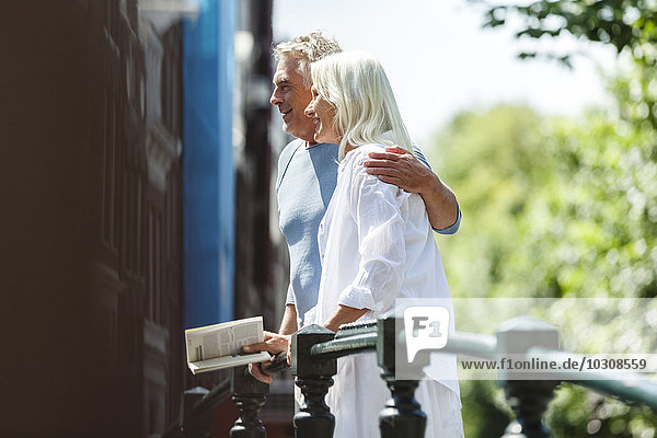 Niederlande  Amsterdam  Seniorenpaar auf einer Brücke umarmend