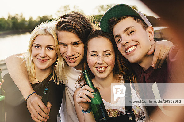 Friends taking a selfie with beer bottles