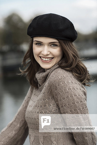 Portrait of happy young woman wearing beret and knitted dress