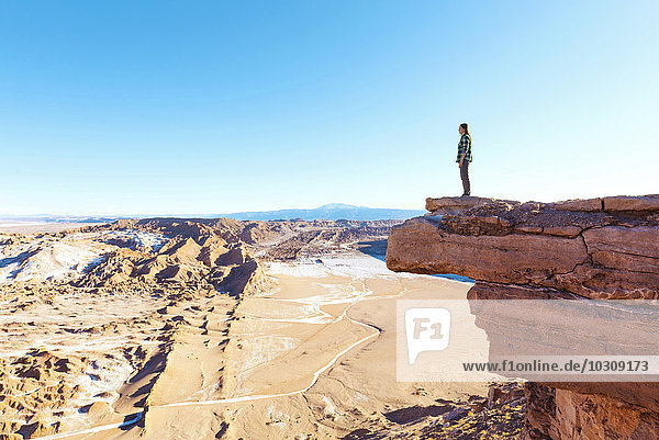 Chile  Atacama-Wüste  Frau steht auf einer Klippe und schaut auf die Aussicht.