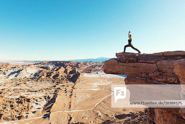 Chile  Atacama-Wüste  Frau steht in Yoga-Pose auf einer Klippe